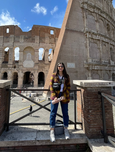 A University of Minnesota student standing in front of a Roman ruin.